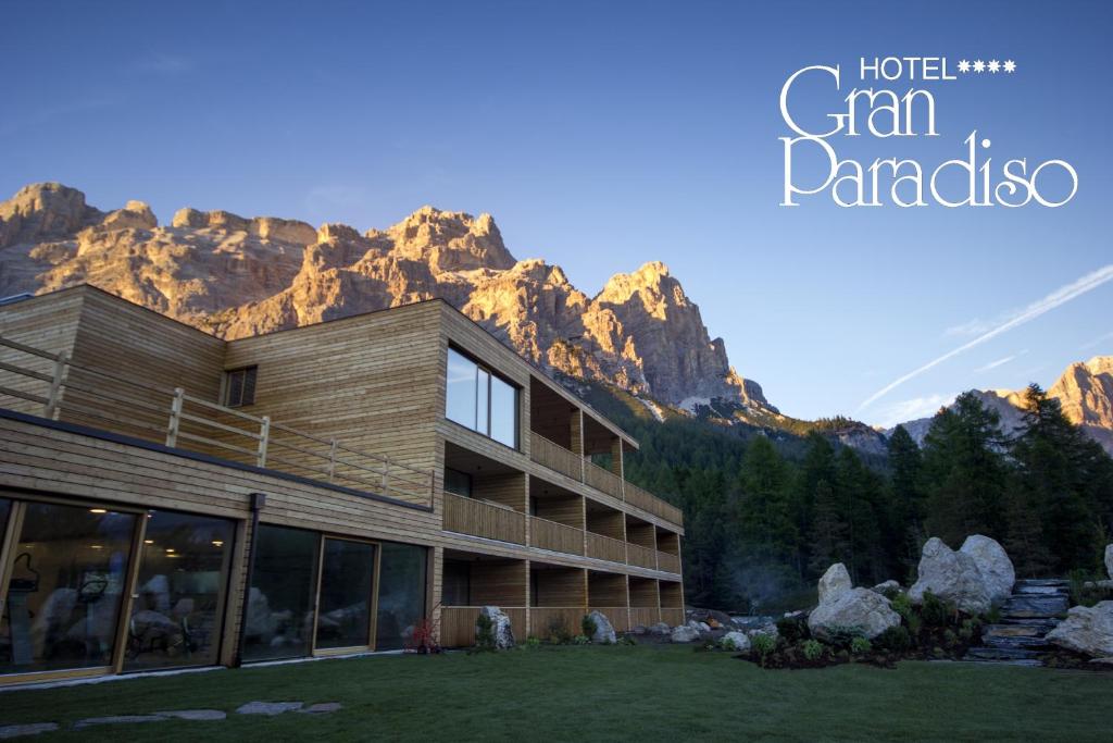 Exterior view of Hotel Gran Paradiso, a multi‑level wooden building with balconies against a mountain backdrop.